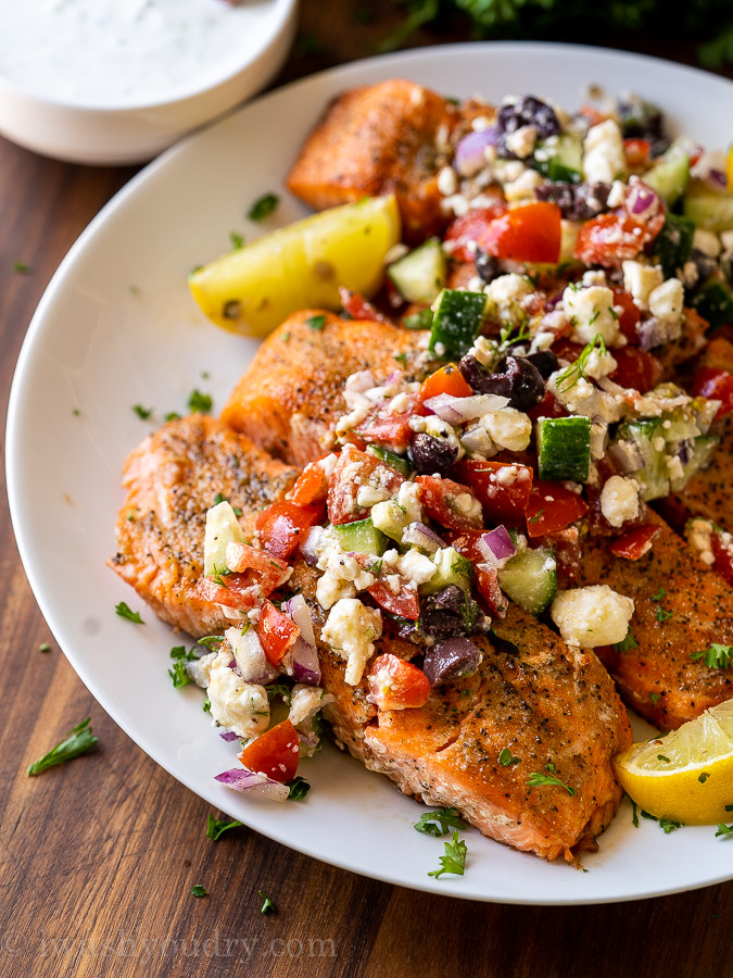 grilled salmon on white plate with greek salsa