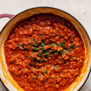 thick spaghetti sauce in pan with fresh herbs