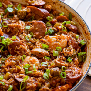 white pan filled with jambalaya with rice and green onions