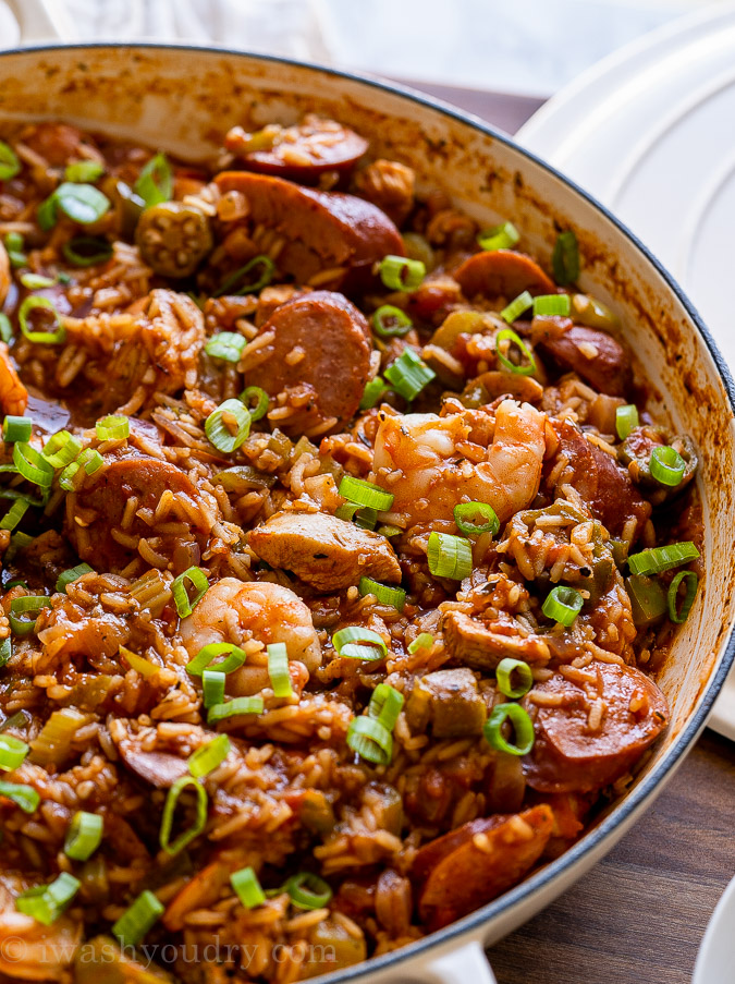 white pan filled with jambalaya with rice and green onions