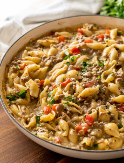 white pan full of ground beef and pasta shells in a creamy sauce