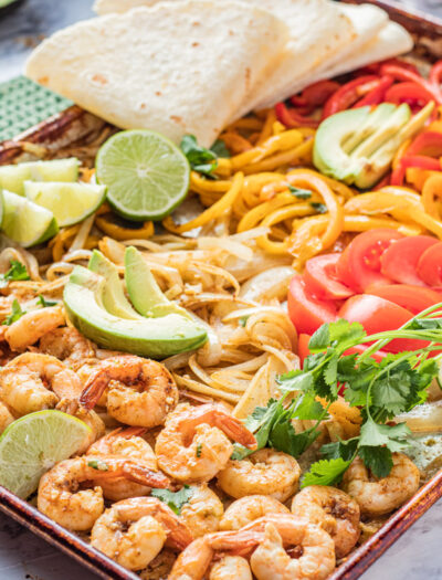 Baked sheet pan shrimp fajitas in a metal pan.