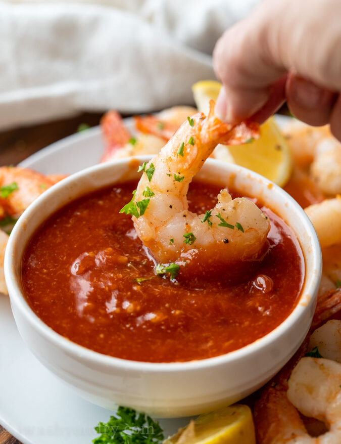 dipping shrimp in cocktail sauce