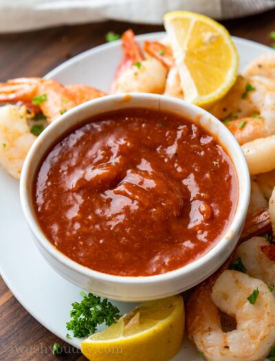 white bowl with cocktail sauce and shrimp