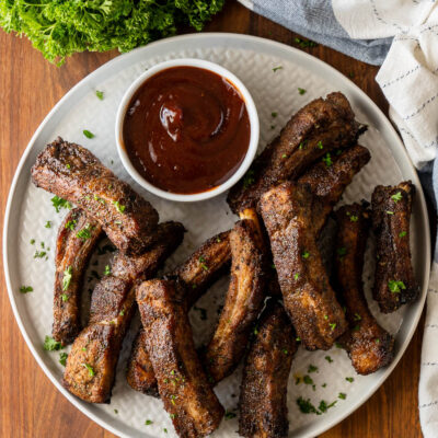 plate of ribs with sauce on the side