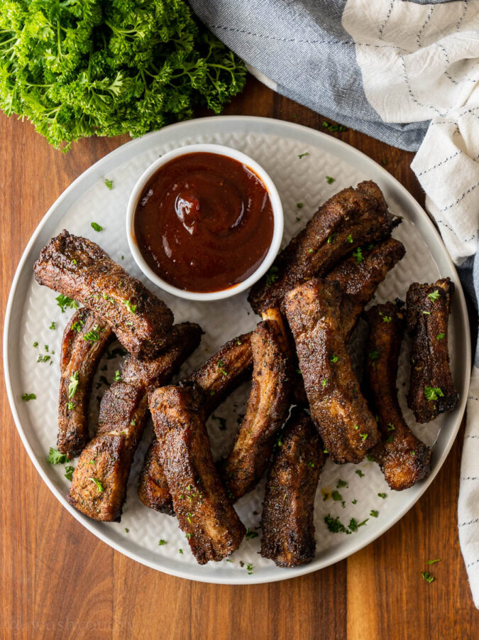 plate of ribs with sauce on the side