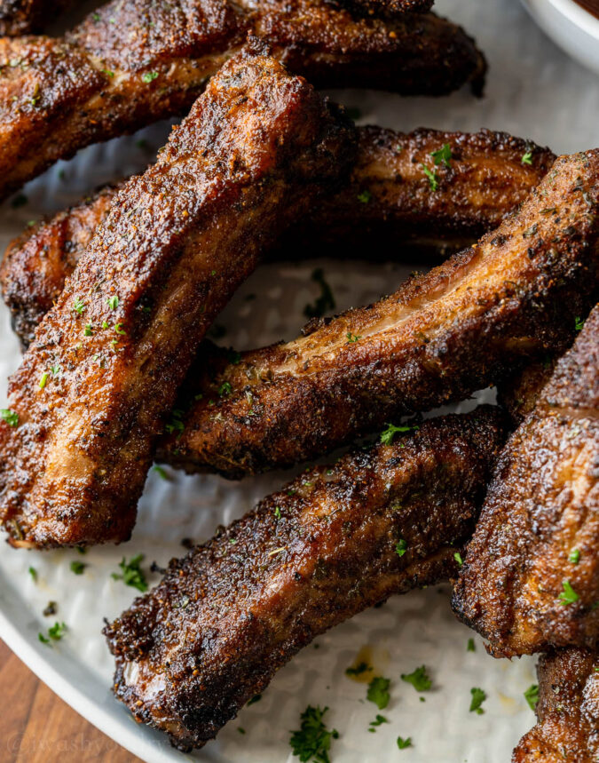 Ribs stacked on plate with parsley garnish