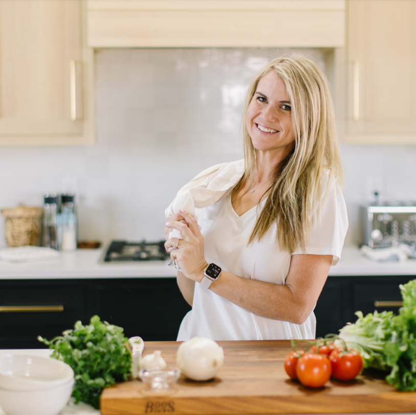 woman in kitchen with towel in hands