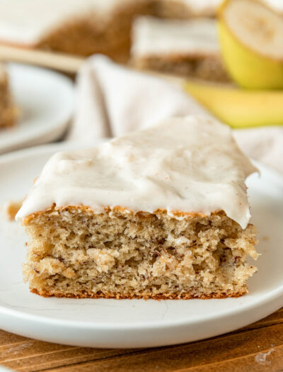 slice of banana cake with frosting on plate.