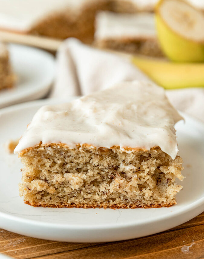 slice of banana cake with frosting on plate.