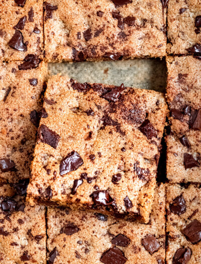 Slice of baked chocolate chip blondie resting on other baked slices.