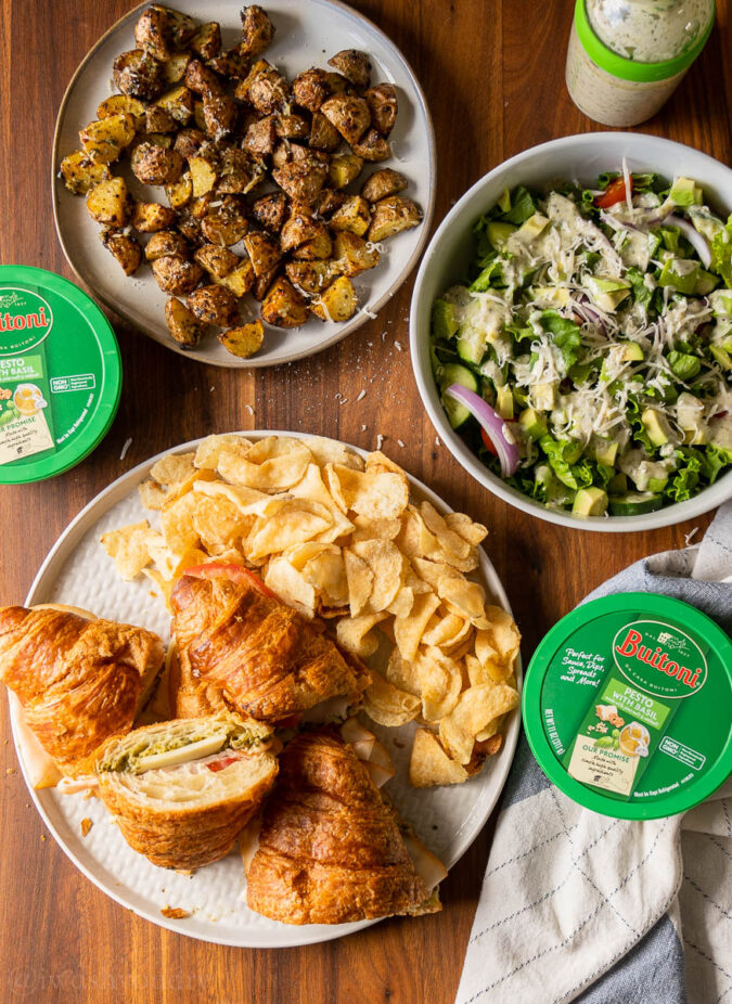 platters of food on table with basil pesto sauce in containers