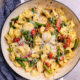 cheesy tortellini in pan with asparagus and tomatoes