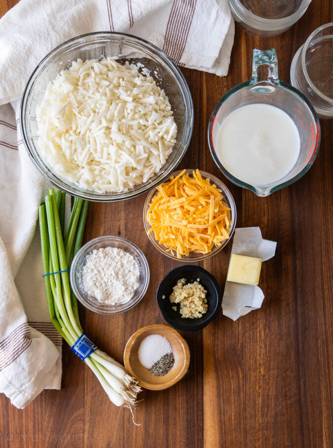 ingredients for au gratin potatoes on wooden surface.