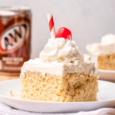 slice of cake on white plate with cherry on top.