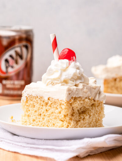 slice of cake on white plate with cherry on top.