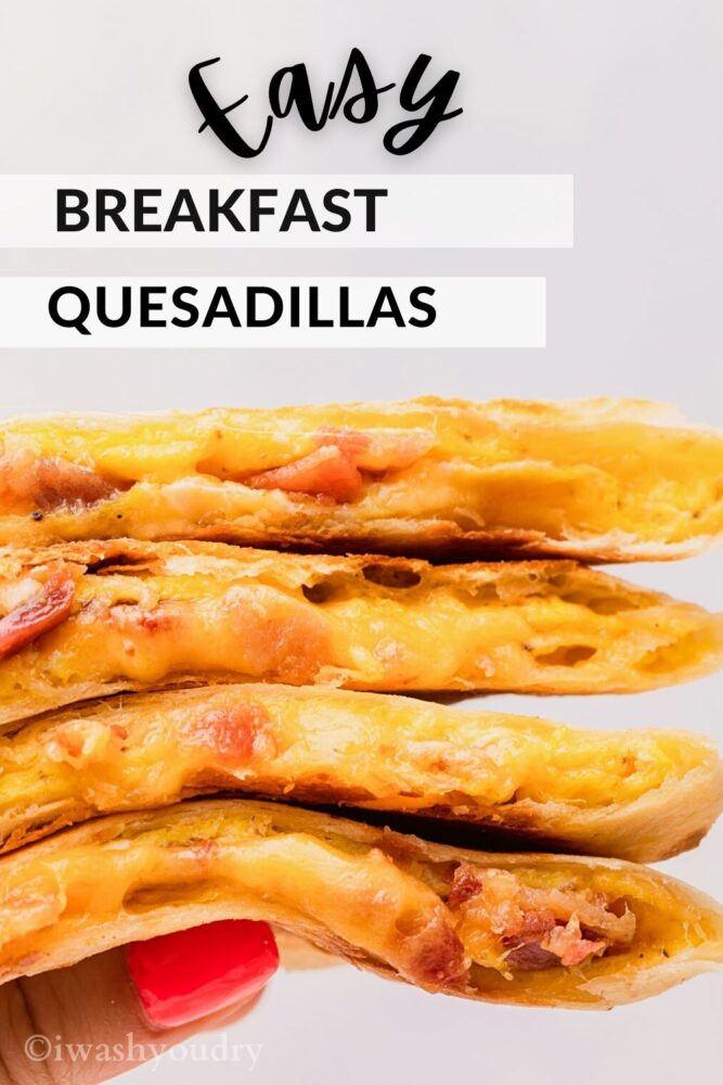 Hand holding stack of cooked breakfast quesadillas