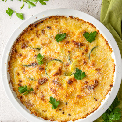 zucchini squash casserole recipe in white dish with parsley