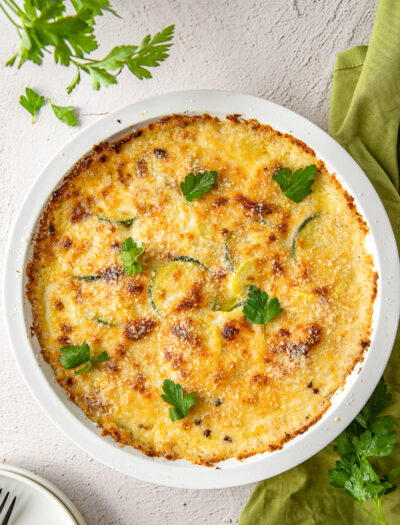 zucchini squash casserole recipe in white dish with parsley