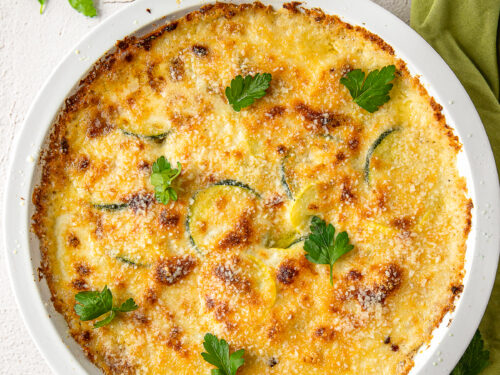 zucchini squash casserole recipe in white dish with parsley