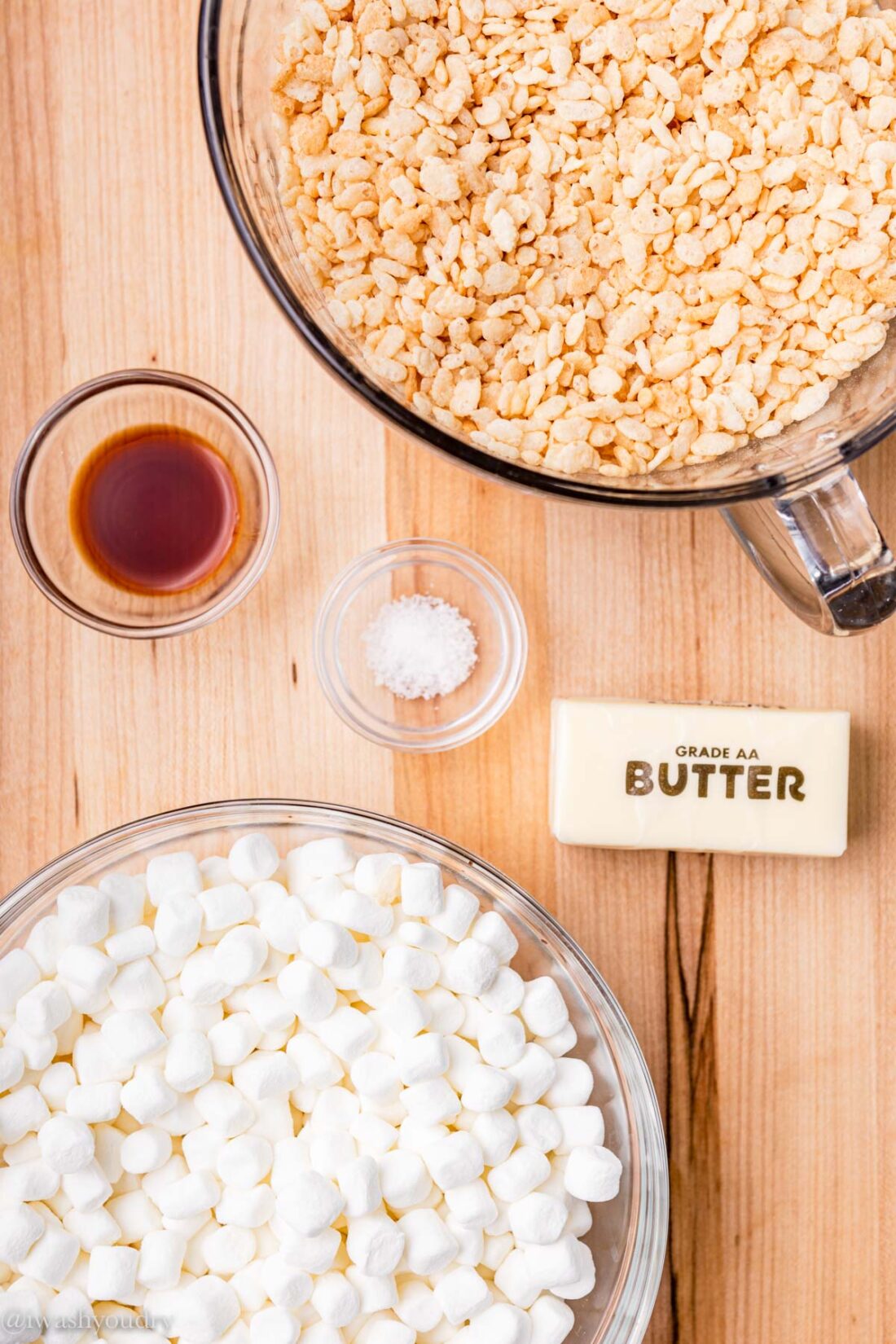 ingredients on wooden surface with marshmallows and cereal.