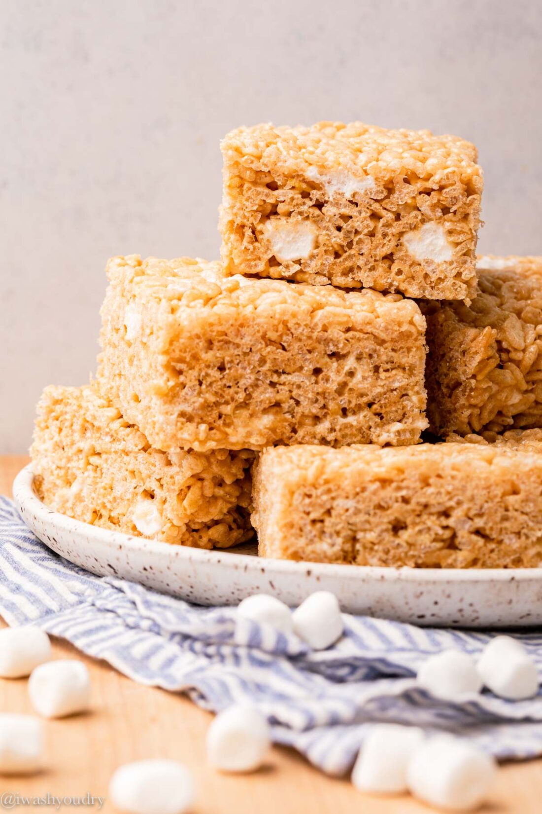 white plate with rice krispy treats piled on top.