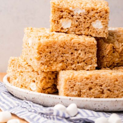 white plate with rice krispy treats piled on top.