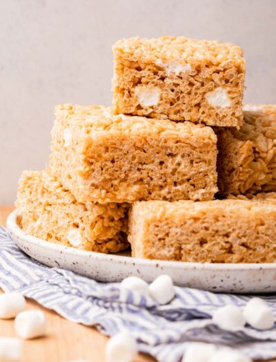 white plate with rice krispy treats piled on top.