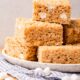 white plate with rice krispy treats piled on top.