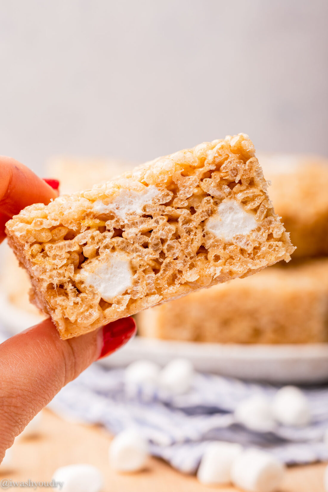 hand holding rice krispie treat with marshmallows.