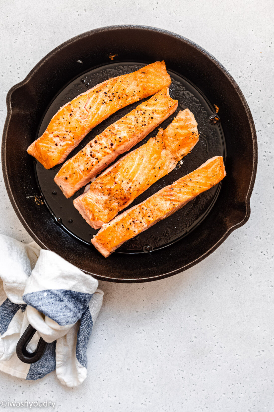 Cooked Lemon Garlic Salmon in black pan. 