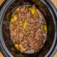 black crockpot with shredded beef and peppers