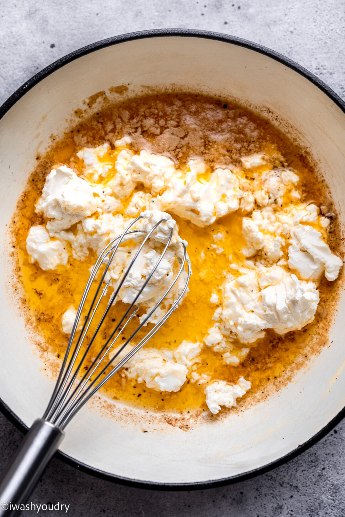 Butter and cream cheese in pan with whisk. 