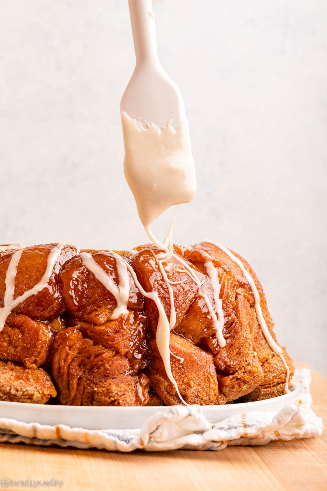 Drizzling glaze over baked monkey bread. 