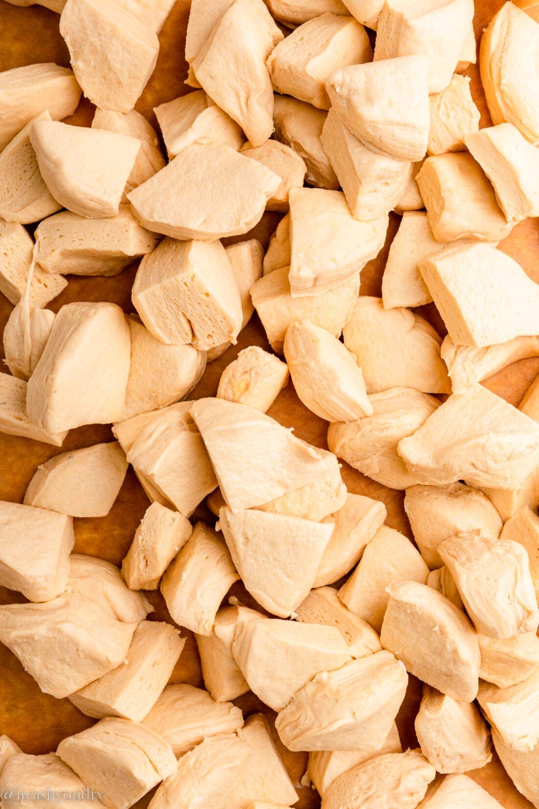 Raw biscuit dough cut into quarter sized pieces. 