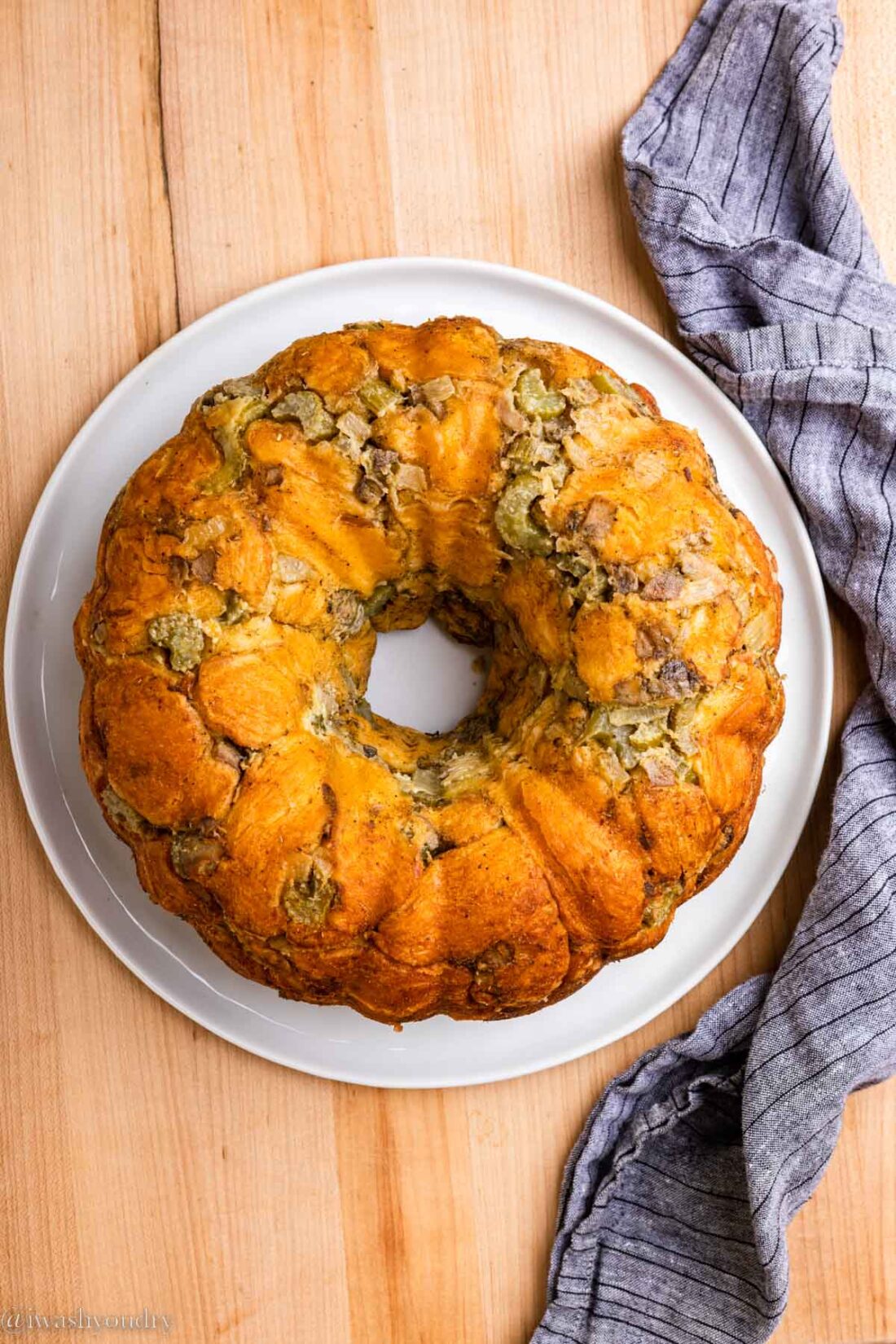 Baked pull apart stuffing ring inverted onto a white platter. 