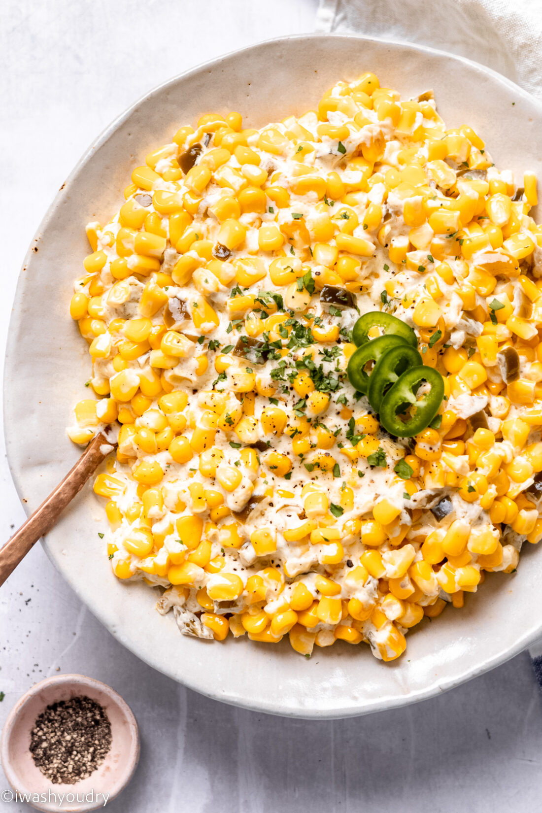 Cooked slow cooker creamed corn in a hwite bowl. 