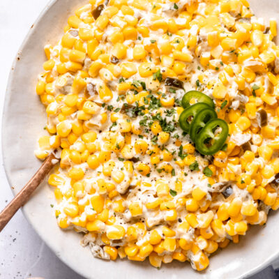 Cooked slow cooker creamed corn in a hwite bowl.