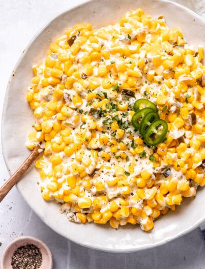 Cooked slow cooker creamed corn in a hwite bowl.