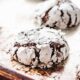 Baked chocolate crinkle cookies on metal pan.