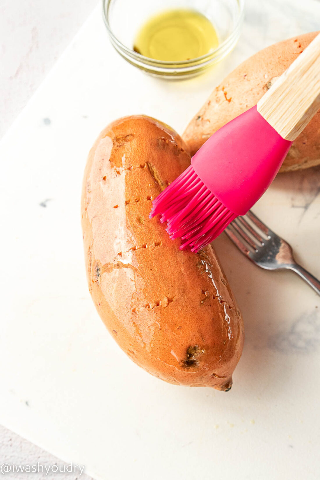 Red brush on whole raw sweet potato. 