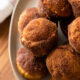 plate full of banana muffins with cinnamon and sugar coating.