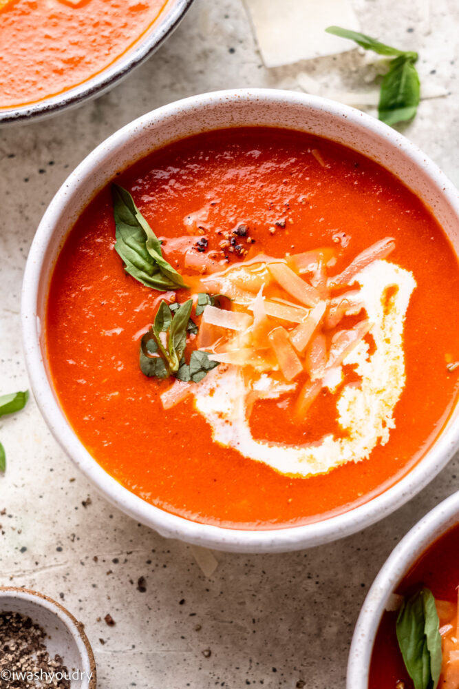 bowl of tomato soup with basil and cream.