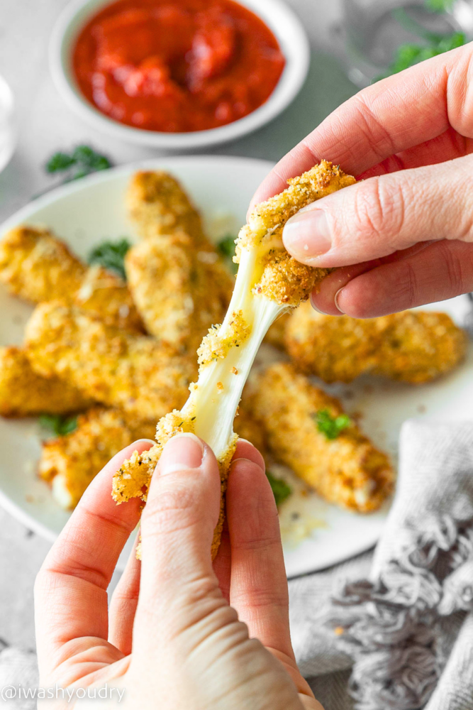 cheese pull of mozzarella sticks with marinara sauce.