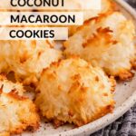 Baked coconut macaroon cookies on white plate with dish towel.