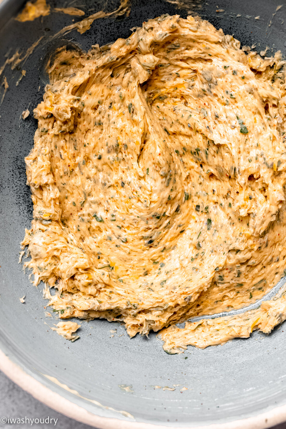 Spices mixed into softened butter in dish. 