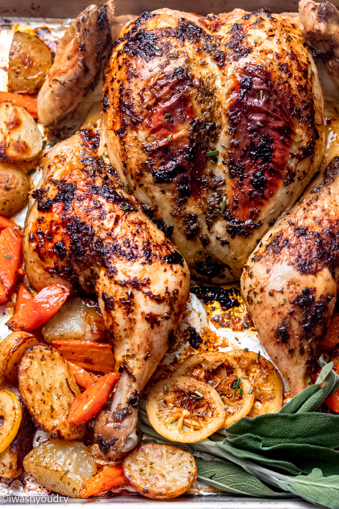 Cooked chicken on metal baking pan with vegetables. 