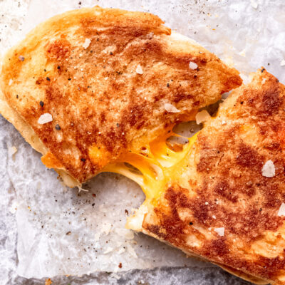 Cooked grilled cheese sadwich on white countertop.