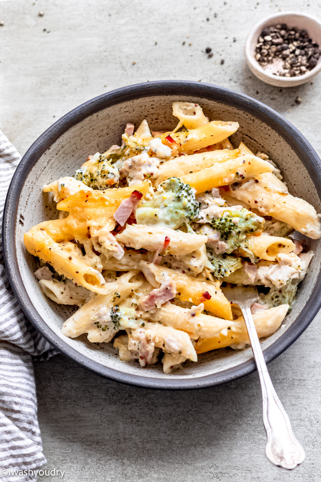 Chicken cordon bleu pasta in gray bowl with spoon. 