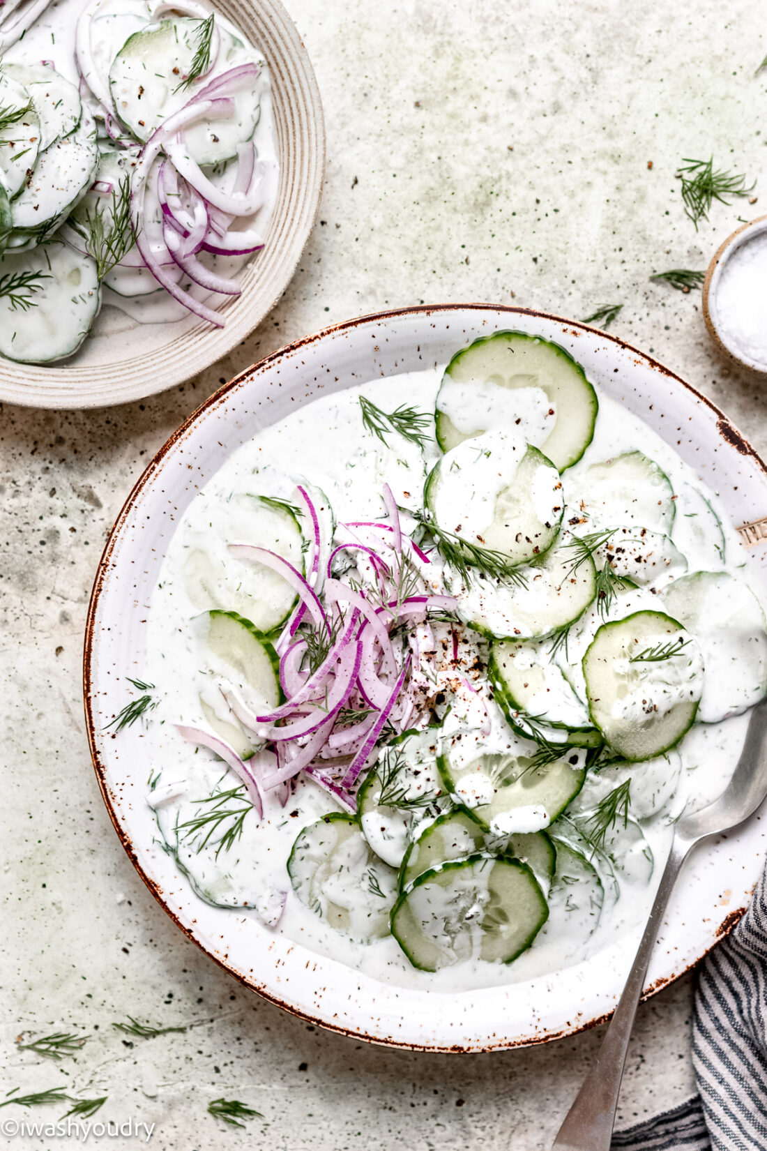 Finished creamy cucumber salad on white plate. 